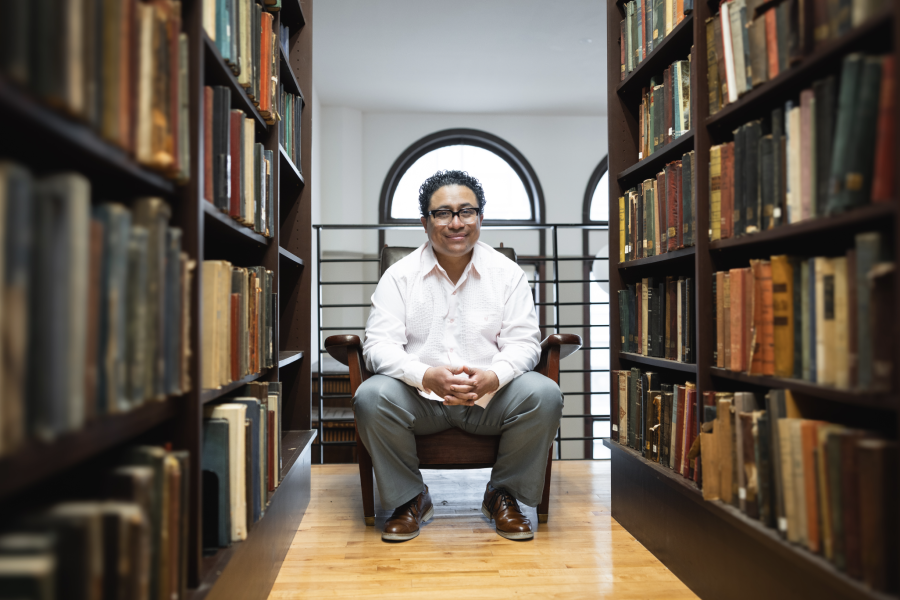 Poet Manuel Iris sitting in a library