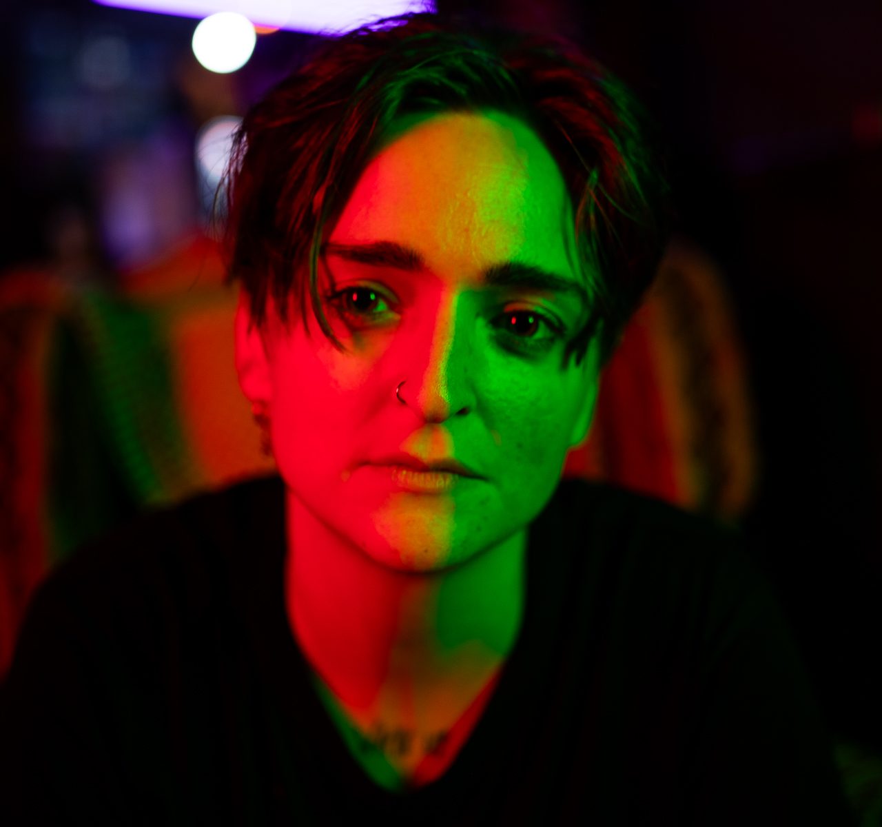 lisa minerva luxx like with red light to the right of their face and green light to the left of their face, looking really cool.