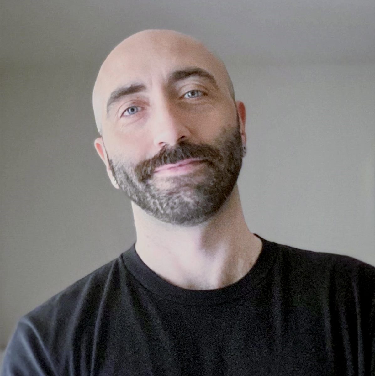Friendly handsome beaded man with dark beard and black t-shirt